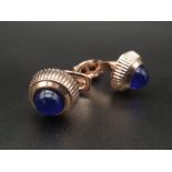 A pair of CARTIER cufflinks with watch crown motif and adorned with blue synthetic spinel,