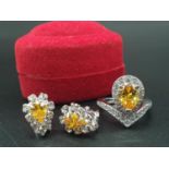 A white metal ring and earrings set with yellow topaz and clear sapphires. Ring size: N. Presented