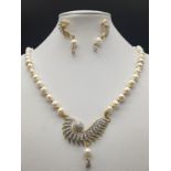 A yellow metal (untested) necklace and earrings set with white pearls and cubic zirconia. In a