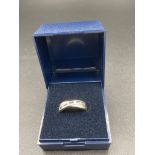 9 carat white gold crossover ring ,having channel set blue and clear stones to top ,classic piece of