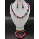 A Chinese cinnabar and lapis lazuli parure set consisting of necklace, bracelet and earrings.