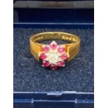 18 carat Gold Ring , Having diamond centre stone with Ruby surround ,piano design to shoulders ,4.