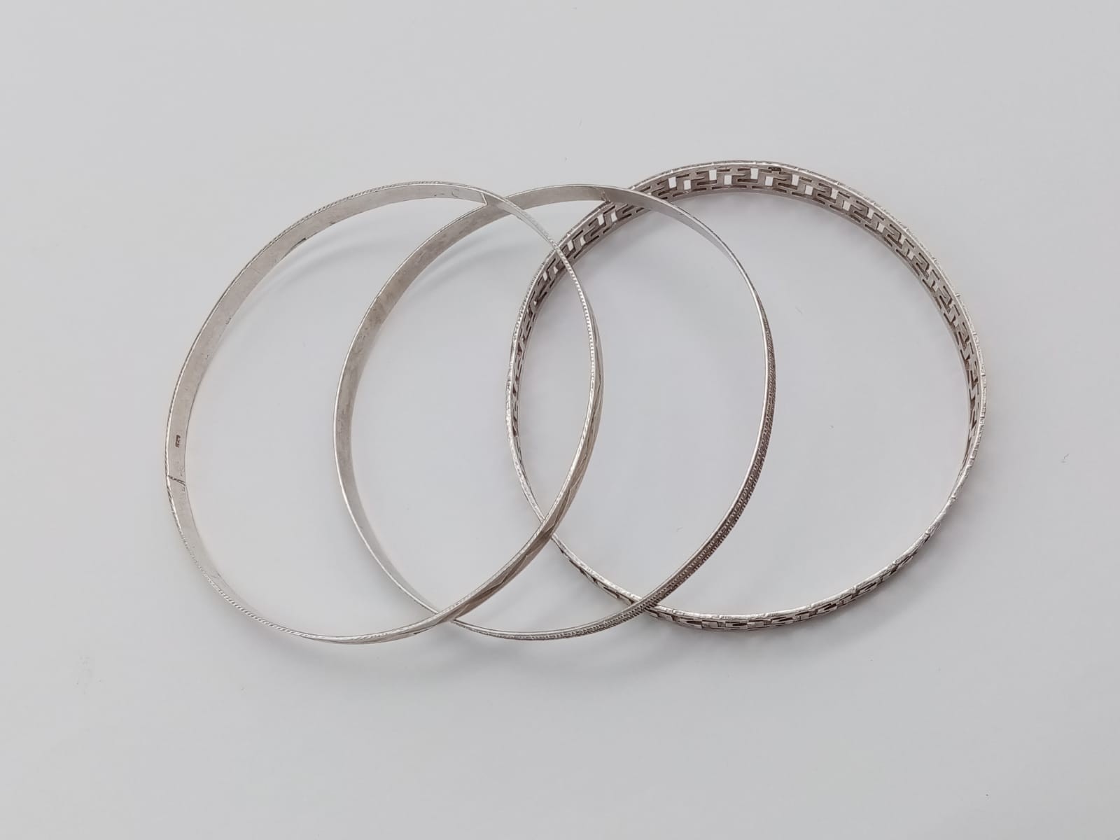 Three Silver Bangles. Different Thicknesses and decorations. 21.39g total weight. 6.5cm diameter.