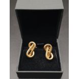 A PAIR OF 18K YELLOW GOLD EARRINGS IN A MODERNISTIC FIGURE 8 SHAPE. 7.91gms (small perforation to