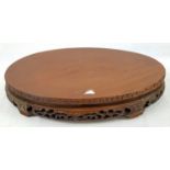 AN EARLY CHINESE OVAL SHAPED WOODEN STAND WITH TRADITIONAL DECORATION. 50 X 32cms 3.6kg