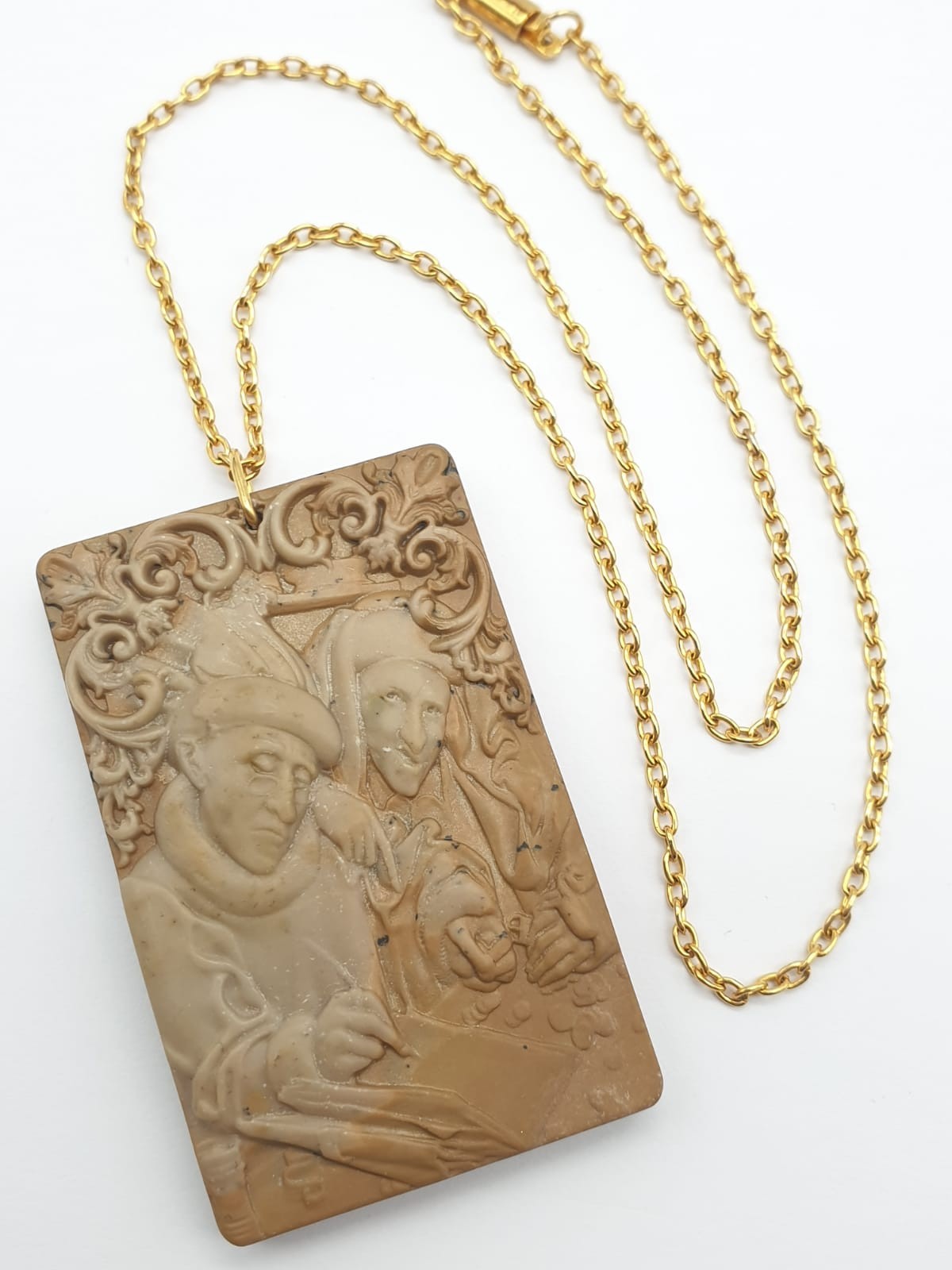 An antique, hand engraved in great detail jasper stone pendant depicting a pair counting money and