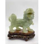 AN 19TH CENTURY JADE FOO DOG TEMPLE LION FIGURE ON WOODEN STAND. 496gms 12 x 10cms