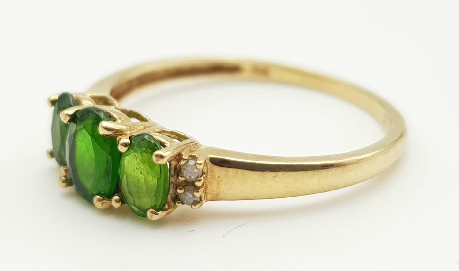 A 9K GOLD RING WITH GREEN TITANITE TRILOGY FLANKED BY 2 SMALL DIAMONDS ON EACH SIDE. 1.45gms size P - Image 2 of 6