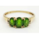 A 9K GOLD RING WITH GREEN TITANITE TRILOGY FLANKED BY 2 SMALL DIAMONDS ON EACH SIDE. 1.45gms size P