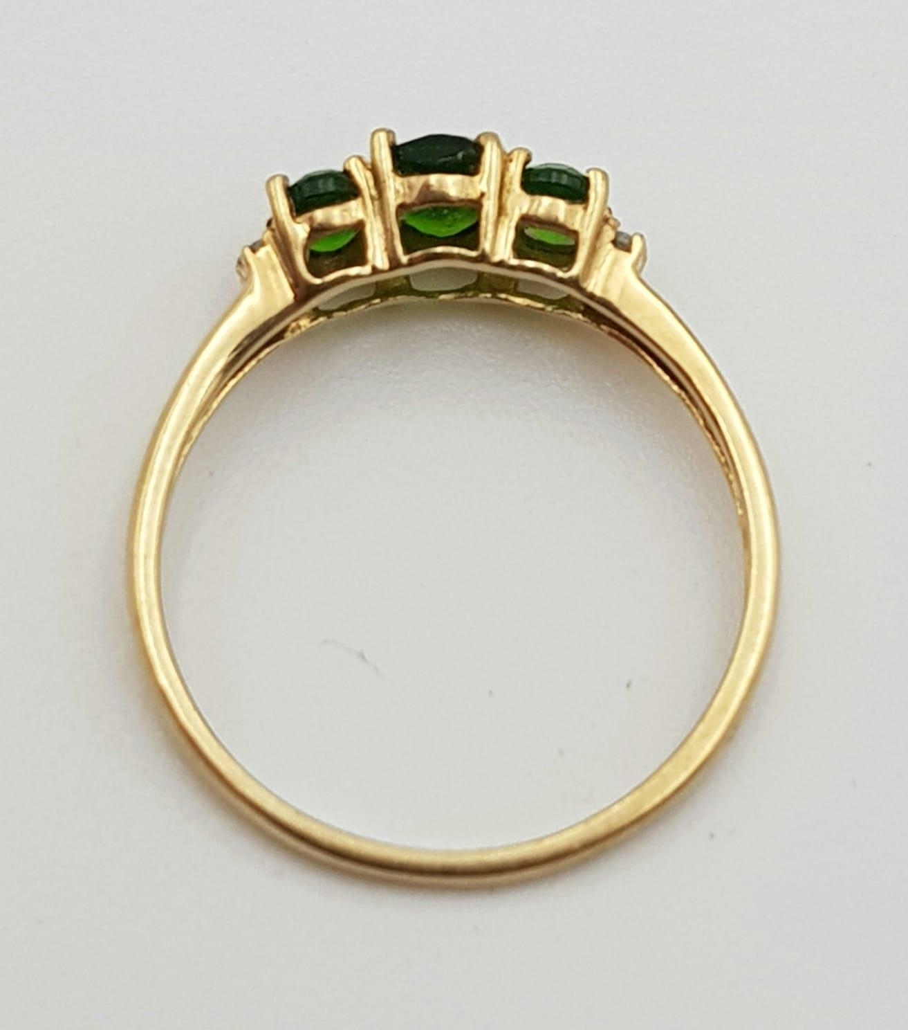 A 9K GOLD RING WITH GREEN TITANITE TRILOGY FLANKED BY 2 SMALL DIAMONDS ON EACH SIDE. 1.45gms size P - Image 3 of 6