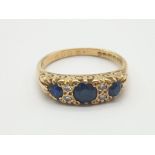 An 18K Yellow Gold Diamond and Three Sapphire Ring. Size N. 4.47g