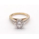 AN 18K GOLD RING WITH A 1.25 SOLITAIRE DIAMOND IN CLAW SETTING WITH DIAMOND SHOULDERS.3.9gms size O