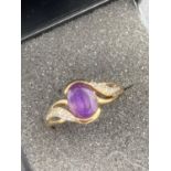 9 carat GOLD and AMETHYST ring ,crossover style and having diamond set shoulders. 2.4 grams . Size