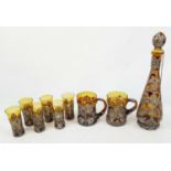 A VINTAGE RUSSIAN AMBER GLASS DRINKING SET DECORATED WITH WHITE METAL. TO INCLUDE A TALL