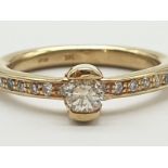 14K Yellow Gold and Diamond Ring. Approx 0.15 Carat centre stone with smaller diamonds on shoulders.