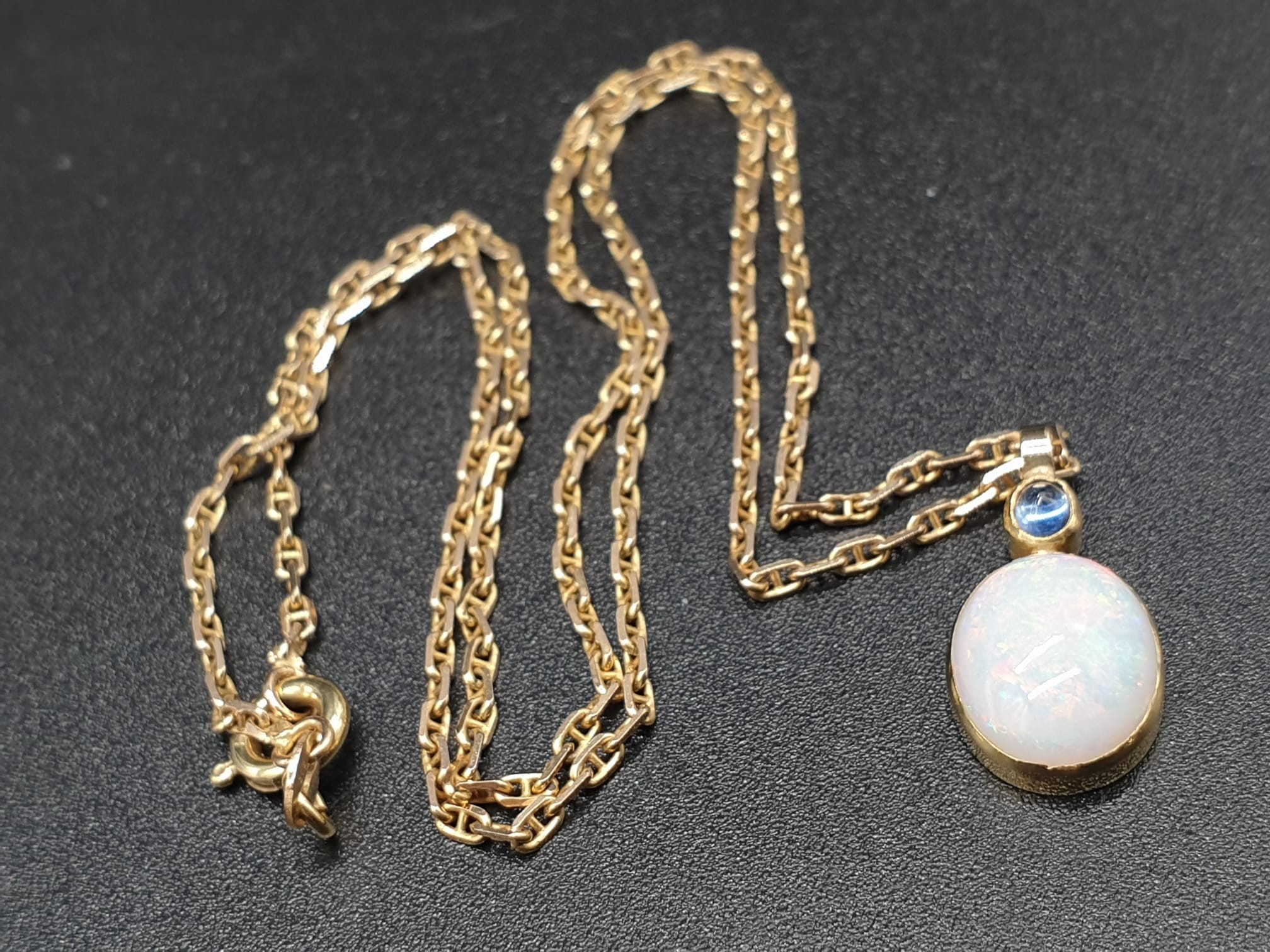 A SAPPHIRE AND OPEL PENDANT ON A 40 cms 9K GOLD CHAIN.