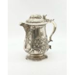 A MAGNIFICENT HAND CHASED SILVER PLATE LIDDED JUG. 745gms 22cms