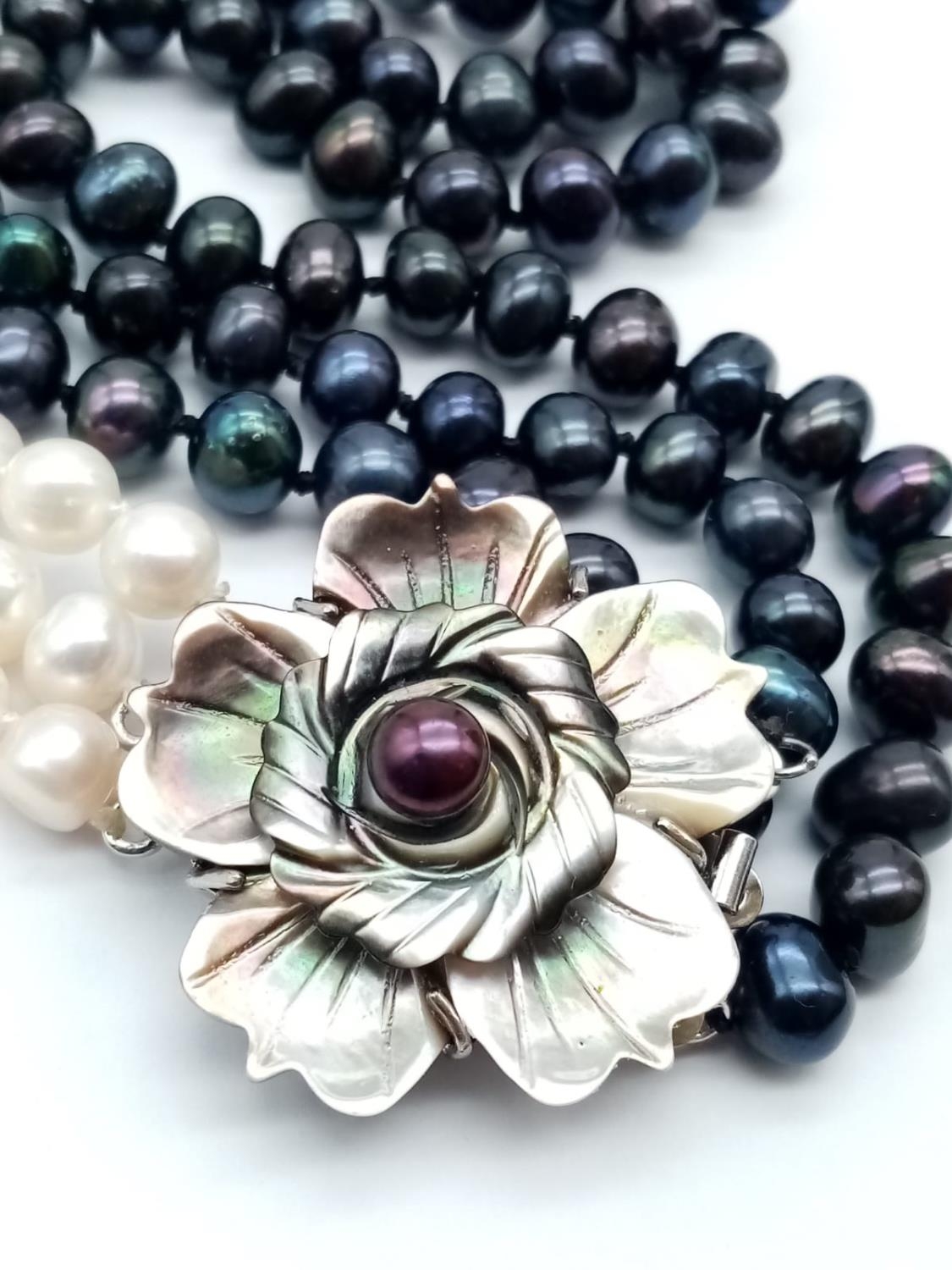 A glamourous, three rows of black and white pearls necklace with a flower shaped, hand carved, - Image 4 of 5