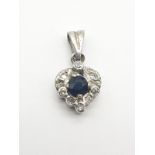 Diamond Encrusted White gold Pendant with Central blue Stone.