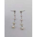 A Pair of Increasing Size Pearl Drop Earrings.