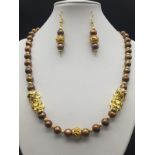 A very attractive, South China sea, chocolate-coloured pearls and Chinese, gold plated Pixius