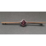 A VINTAGE 9K ROSE GOLD BAR BROOCH WITH CENTRAL SQUARE AMATHYST STONE. 3.1gms 6cms