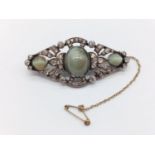 A rare vintage brooch with three central cat's eyes oval stones surrounded by diamonds. With extra