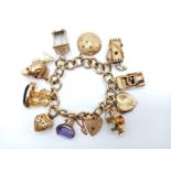 A Vintage 9K Yellow Gold Charm Bracelet with Eleven Eclectic 9K Yellow Gold Charms - Some with