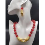 A Chinese red jade and gold filled dragons necklace and earrings set in a presentation set. Necklace