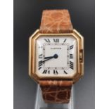 An 18K yellow gold Cartier watch with leather strap in good condition and working order. 27 mm case.