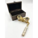 A Brass and Mother of Pearl Pair of Opera Glasses - with fold-up handle. Good condition, comes in