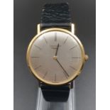 AN 18K GOLD SLIMLINE LONGINE GENTLEMANS WRIST WATCH WITH SILVER FACE AND MANUAL MOVEMENT.