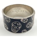 A Fashion statement: An ALEXANDER McQUEEN black enamel bracelet with skulls. Bracelet width: 35