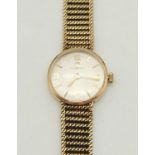 A Vintage 9K Yellow Gold Omega Ladies Dress Watch. 9K yellow gold strap and case. Silver dial.