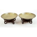A vintage pair of Chinese brass bowls engraved with dragons and letters on custom made wooden bases.