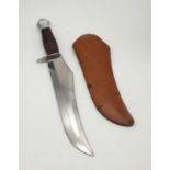 A Large Buffalo Hunter Branded Knife and Skinner. Leather scabbard. Wood handle. 25cm length of