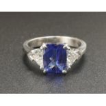 A BEAUTIFUL 2CT CUSHION CUT SAPPHIRE CENTRE STONE FLANKED BY TWO LARGE TRIANGULAR DIAMONDS SET IN
