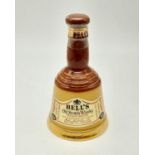 A Bells Scotch Whiskey Ceramic Decanter Bottle. The Whiskey remains inside! 16cm tall.