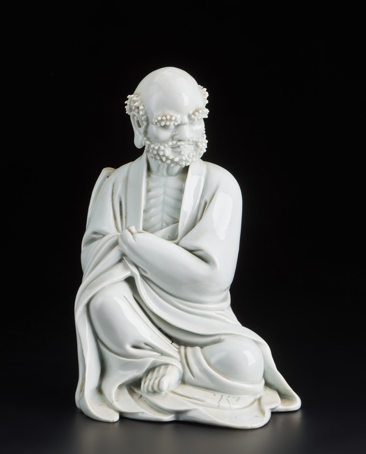 Arte Cinese A Blanc de Chine porcelain figure of a seated LohanChina, 19th century .