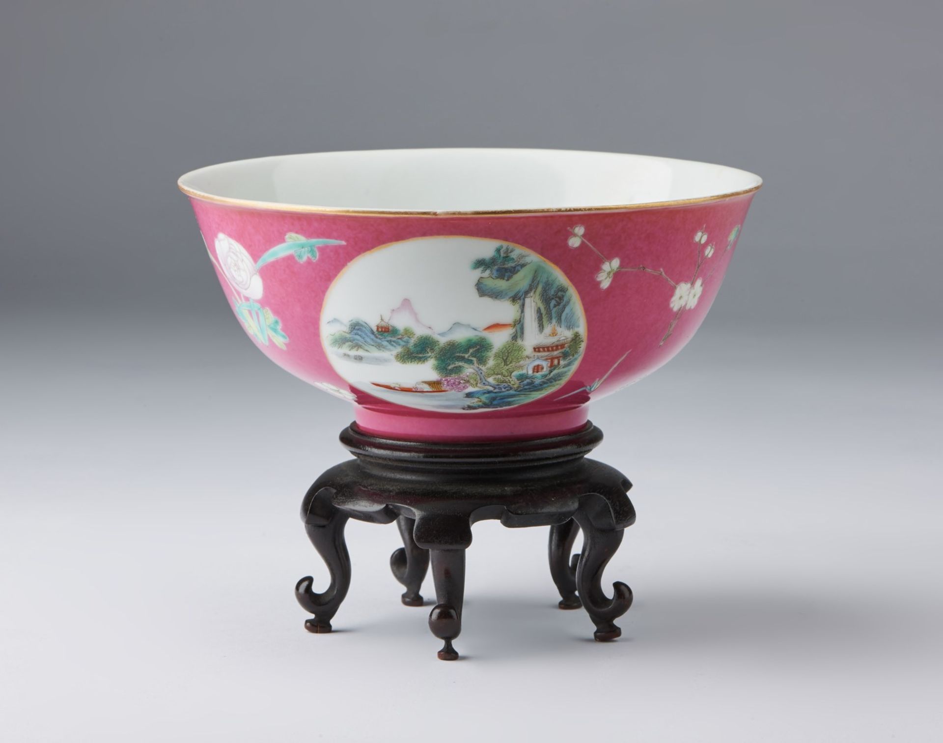 Arte Cinese A famille rose porcelain bowl painted with landscapes and bearing a Qianlong red mark a