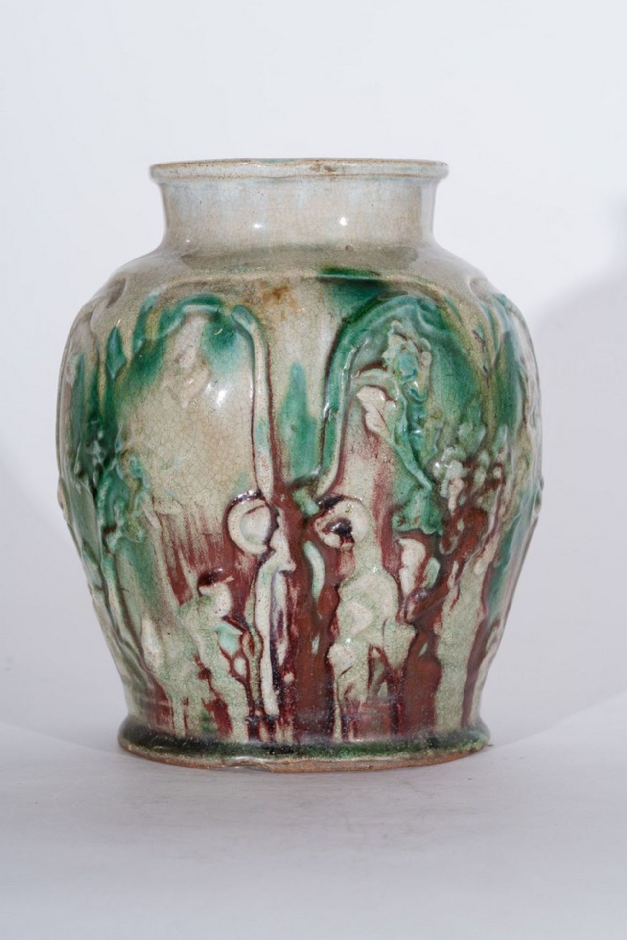 Arte Cinese A Sancai style vase moulded with floral motifs and glazed with dashes of green strainsC