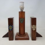 An early 20th century oak lamp base, painted with a crest, 24 cm, and a pair of similar bookends, in