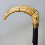 A walking stick, the ivory handle carved in the form of a horn, on ebony shaft
