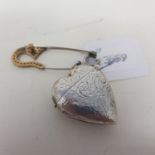 A modern silver coloured metal novelty vesta, in the form of a heart, and a pin (2)