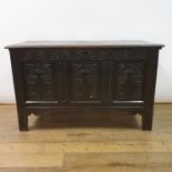 An 18th century oak coffer, with later carved decoration, 123 cm wide