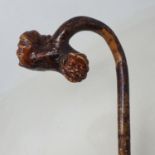 A folk art walking stick, the handle carved in the form of two male heads, 96 cm