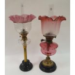 An oil lamp, with cranberry glass shade, cranberry well, on brass base, 58 cm high, and an oil lamp,