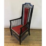 An Arts & Crafts ebonised armchair, with a slatted and padded back and seat, on tapering square legs