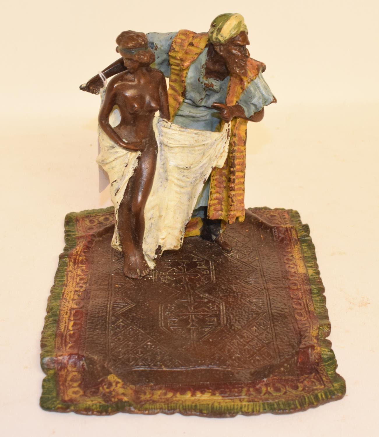 A modern painted bronze figure of a trader, standing on a rug, 16 cm high