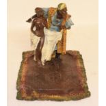 A modern painted bronze figure of a trader, standing on a rug, 16 cm high